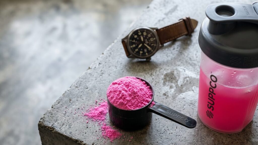 Pre-workout powder scoop and shaker bottle on a counter, illustrating how long pre-workout effects last.